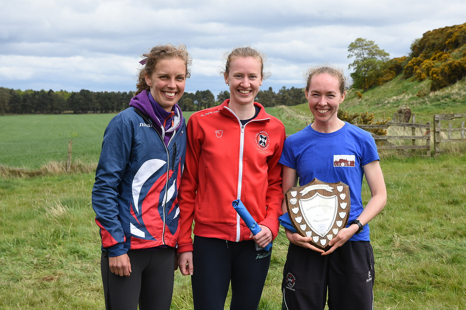 Three female orienteers with trophy at Scottish Orienteering Championships in the Scottish Countryside